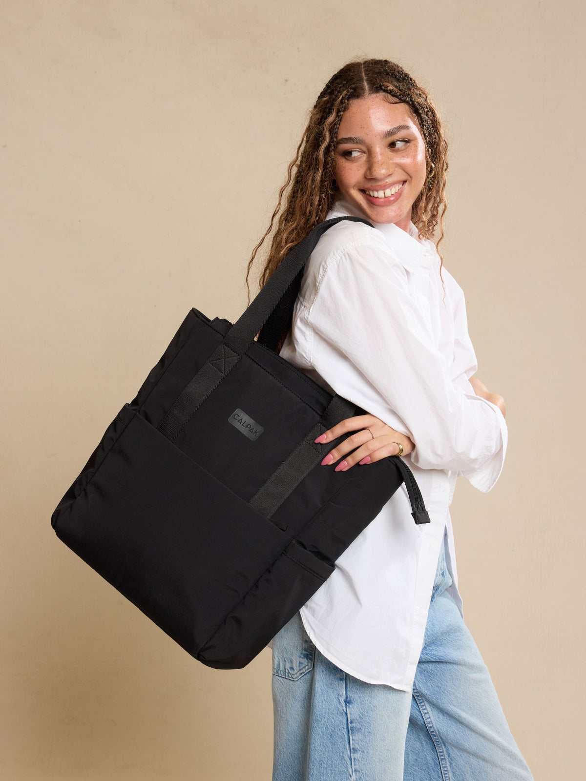 Model wearing the CALPAK Connect Laptop Tote in Black