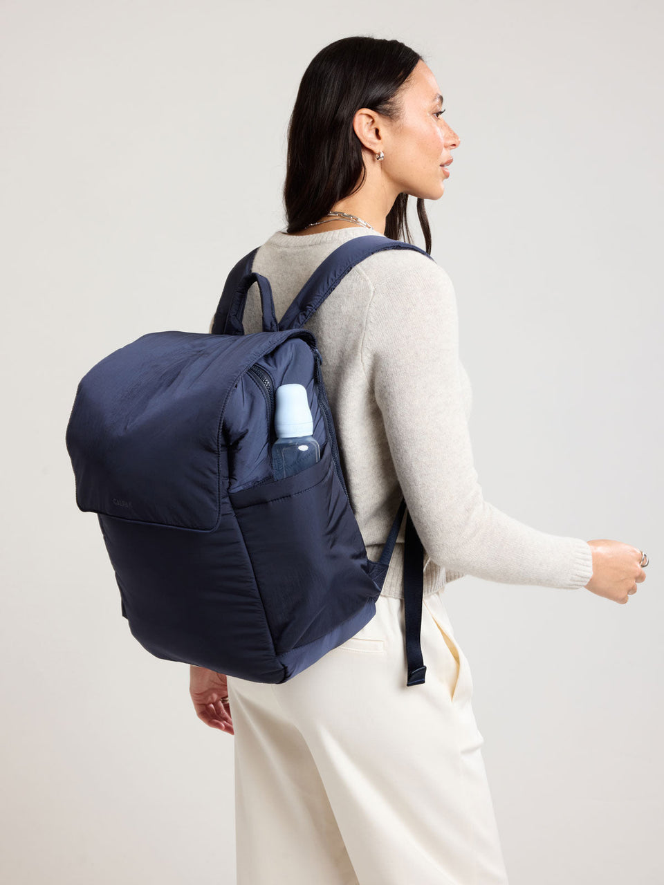 Woman wearing the CALPAK Diaper Mini Backpack in dark blue Navy
