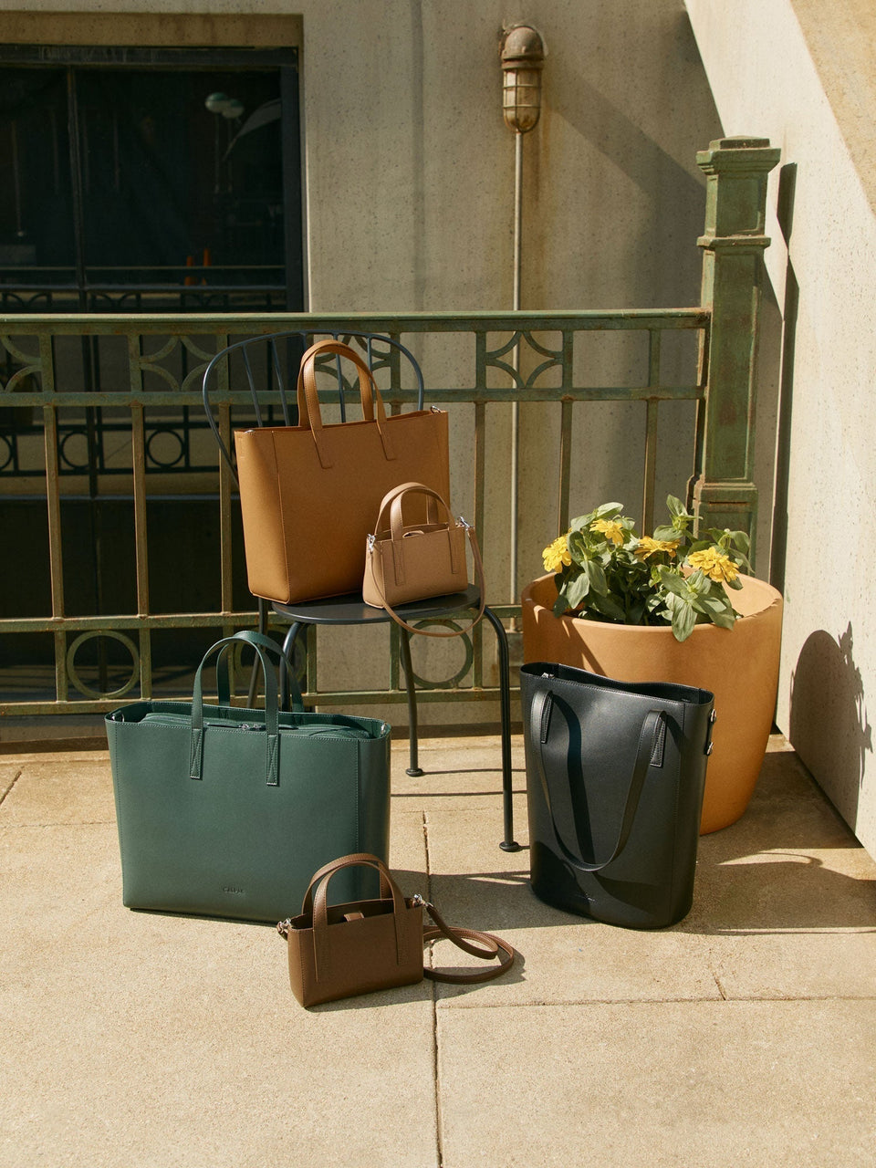 CALPAK Haven Tote Bags assembled on stools outside with railing