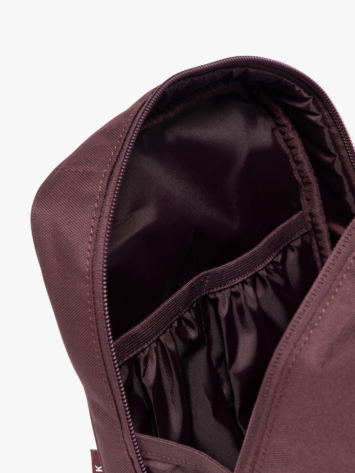 Closeup of the inner compartments of Dark burgundy Dark Cherry color of the CALPAK Everything Cube organizer with a top handle, a front zippered pocket, and a textured mesh lower panel, shown against a plain white background; ACE2401-DARK-CHERRY