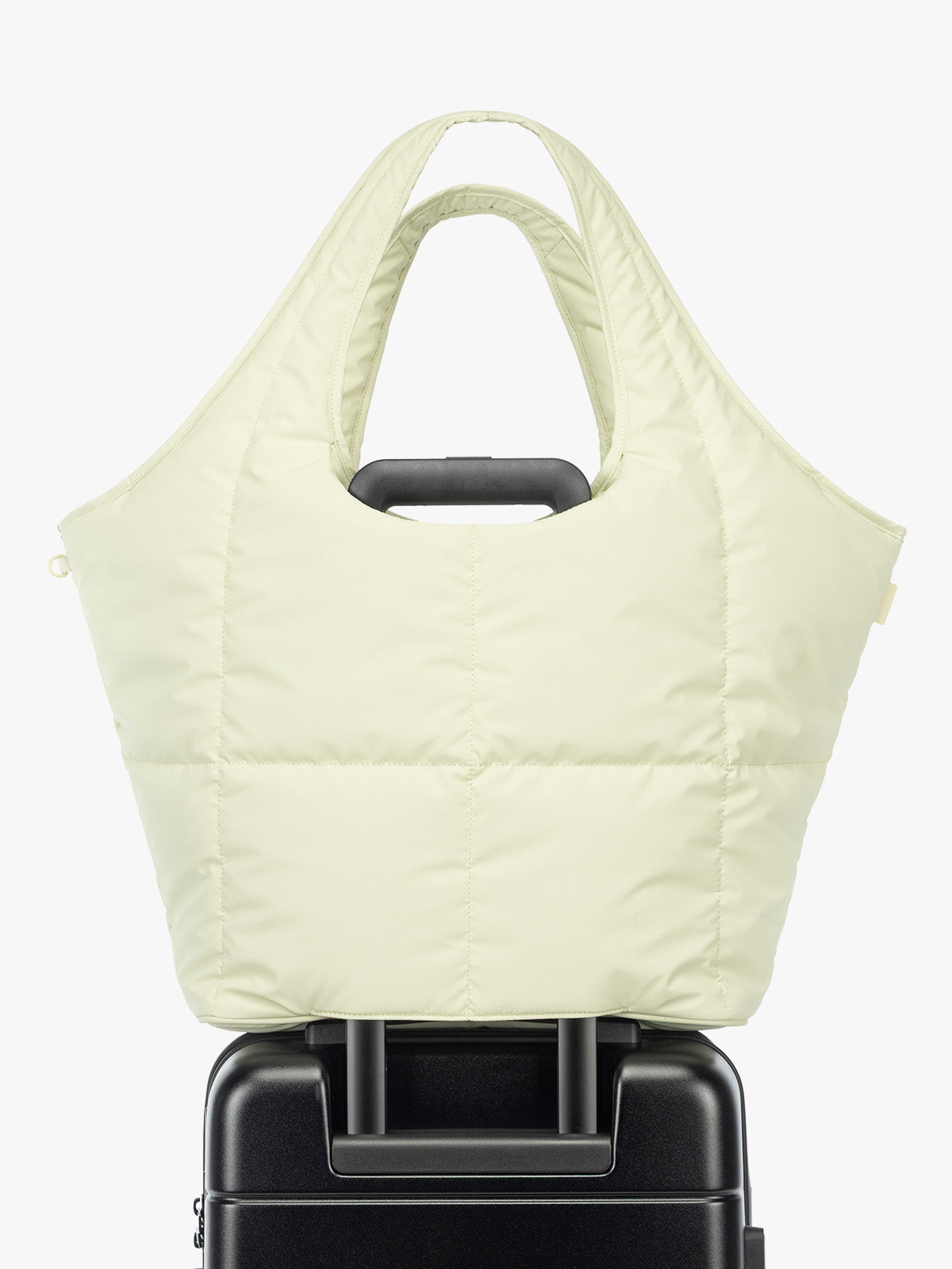 Luggage trolley sleeve of the CALPAK Luka Everything Laptop Tote in light green Celadon with shoulder strap on a white background; AET2601-CELADON