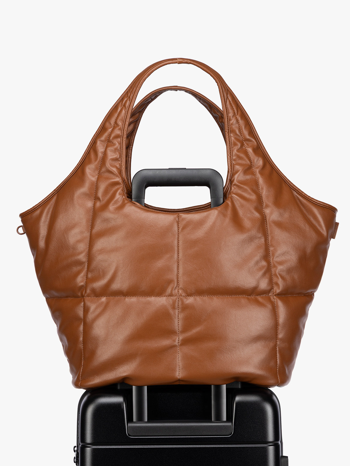 Luggage trolley sleeve feature of the Honey Brown quilted puffer CALPAK Luka Everything Tote Bag with a smooth finish and double shoulder straps, shown against a plain white background; AET2601-HONEY-BROWN-PU