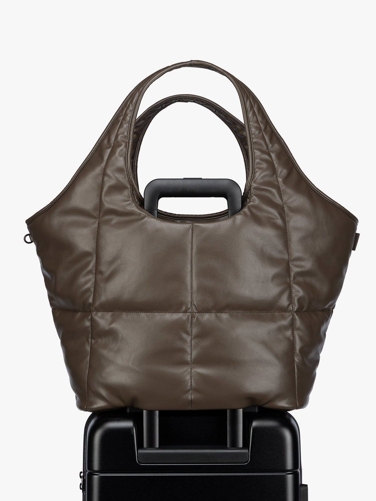 Luggage trolley sleeve of the Mushroom brown quilted puffer CALPAK Luka Everything Tote Bag with a smooth finish and double shoulder straps, shown against a plain white background; AET2601-MUSHROOM-PU
