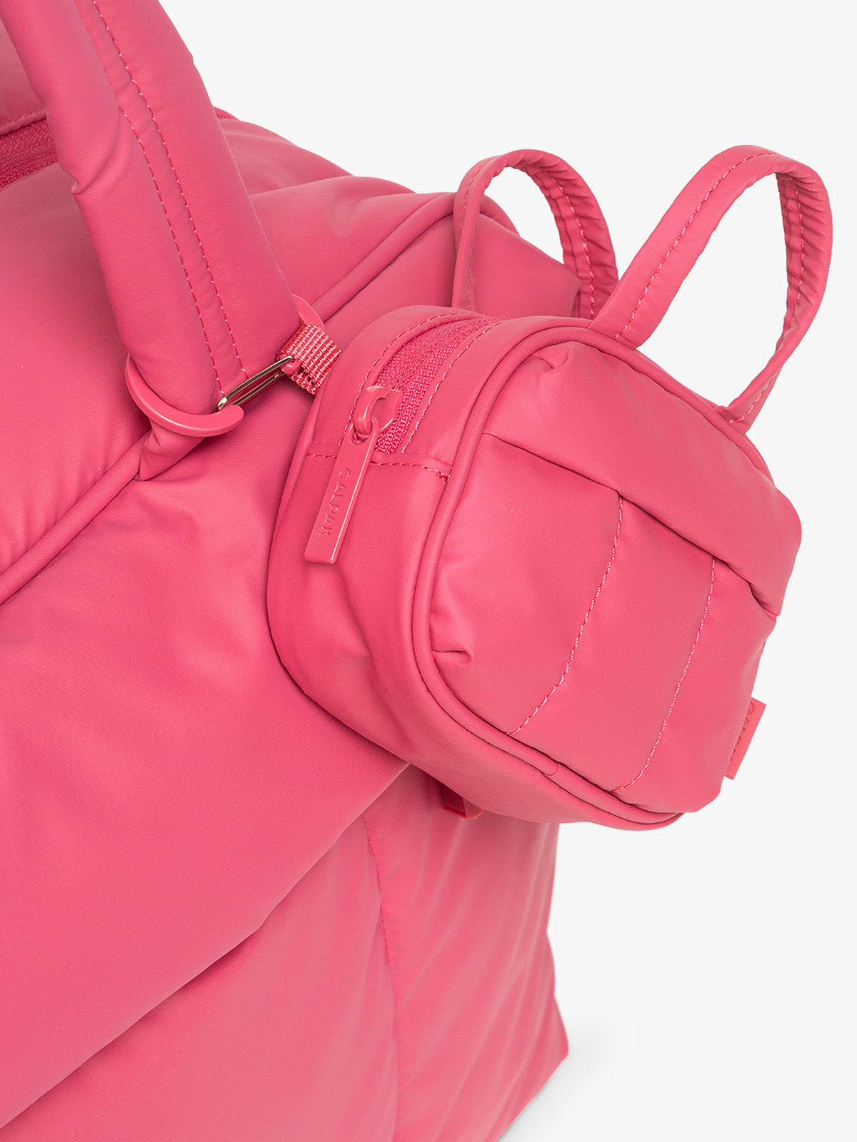 Close up of CALPAK Luka Duffel Zip Bag Charm in bright pink Dragonfruit on the CALPAK Luka Mini Duffel in bright pink Dragonfruit; ALK2501-DRAGONFRUIT