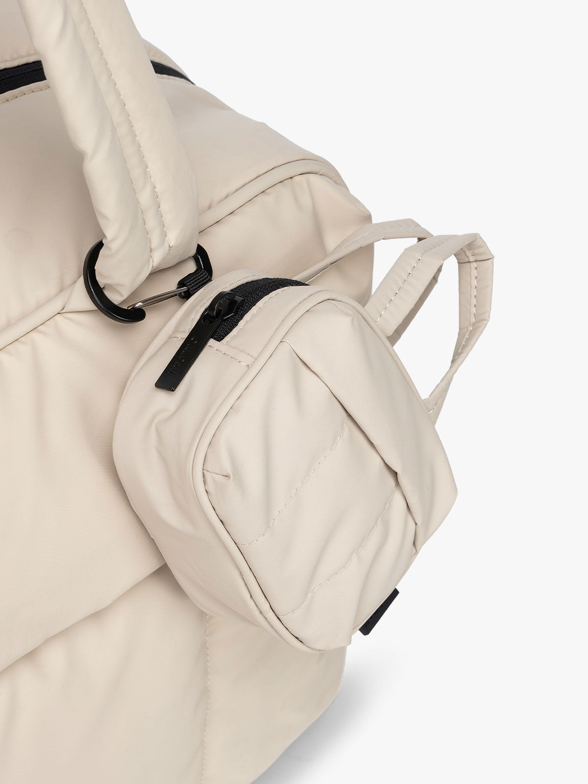 CALPAK Luka Duffel Key Pouch in white Oatmeal clipped onto the Luka Duffel in white Oatmeal; ALK2501-OATMEAL