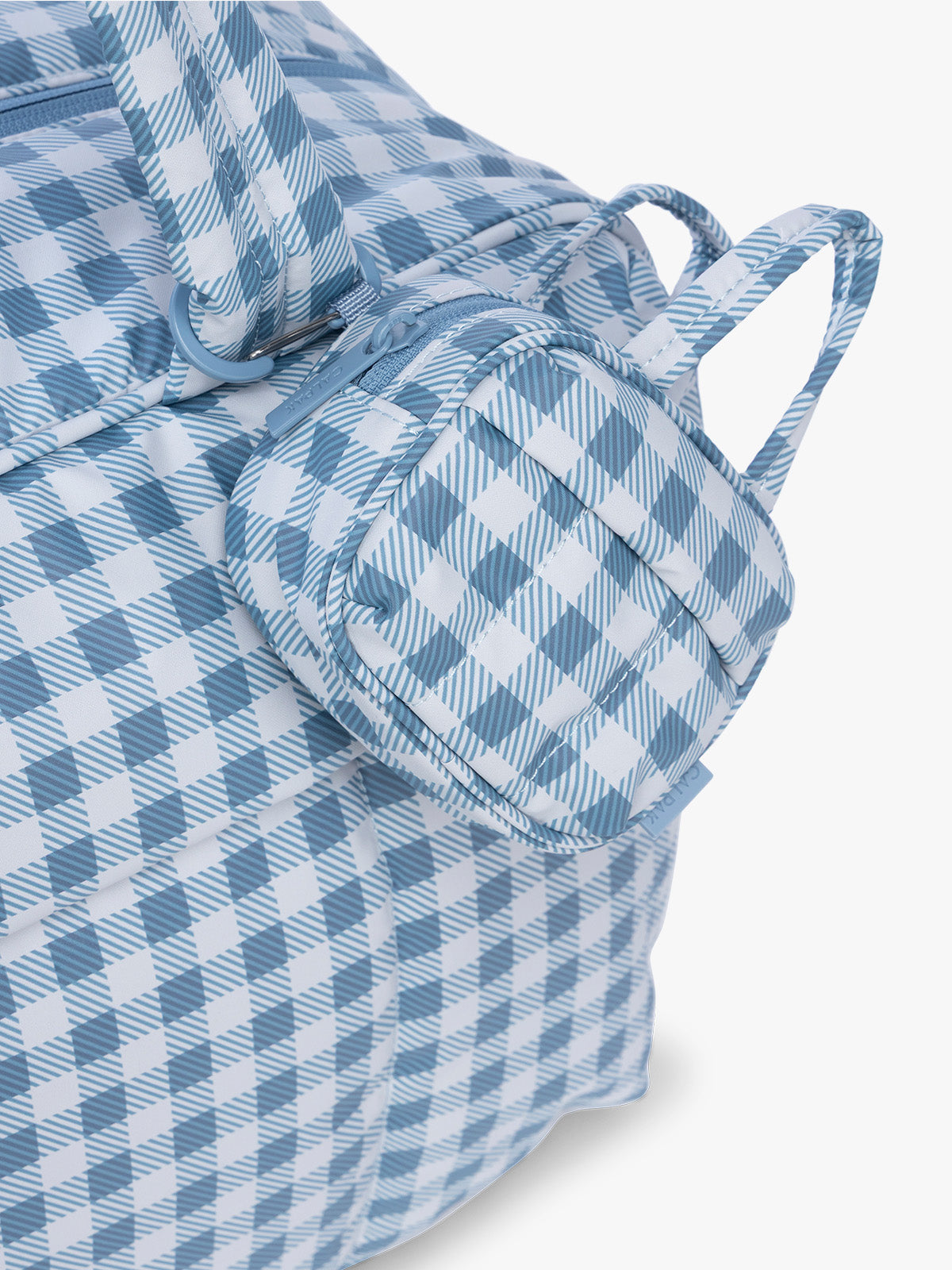 CALPAK Luka Duffel Zip Bag Charm in white and blue gingham print in French Blue Gingham clipped on a bag; ALK2501-FRENCH-BLUE-GINGHAM