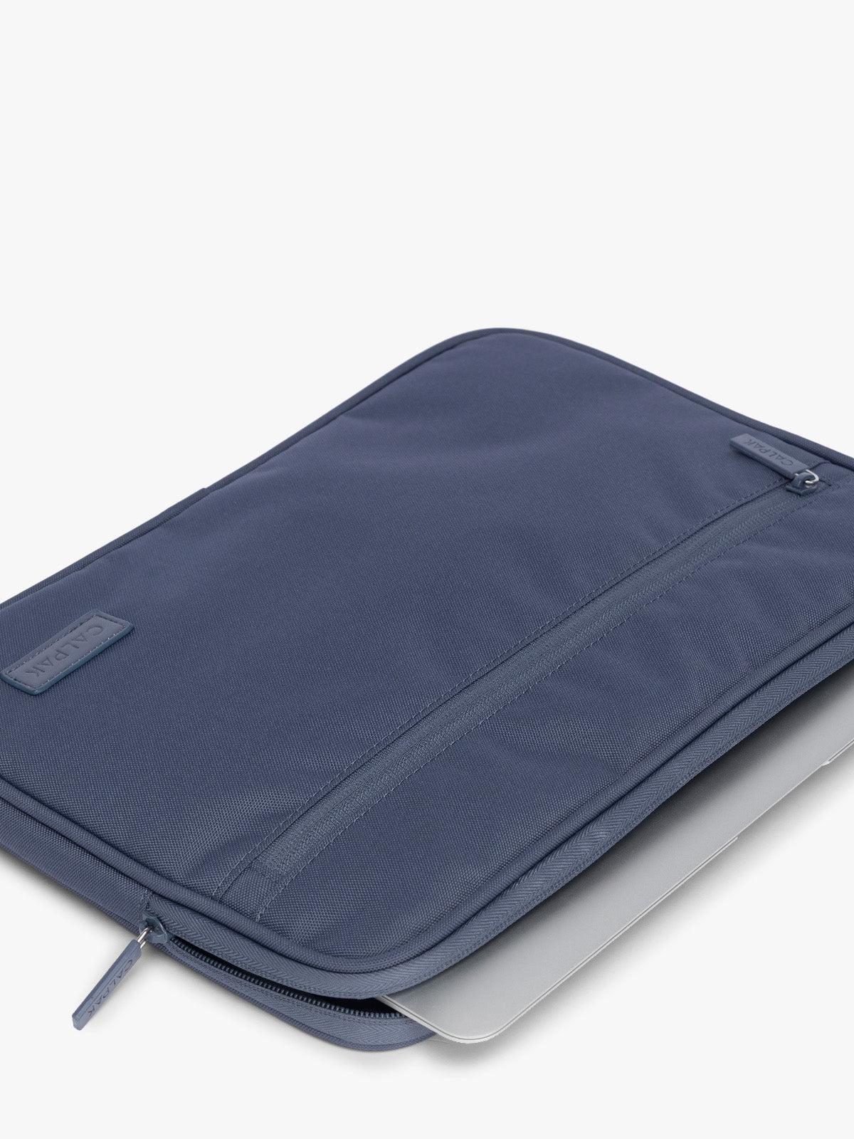 Flatlay with laptop inside of CALPAK Padded Laptop Sleeve 13" in dark blue Indigo; ALP2213-INDIGO