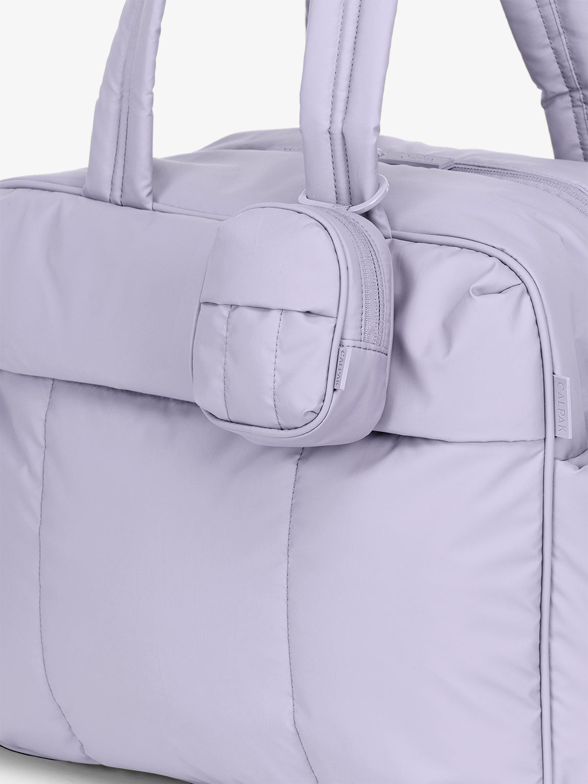 CALPAK Luka Keypouch clipped onto strap of the CALPAK Luka Duffel lavender purple Orchid; AMB2201-ORCHID