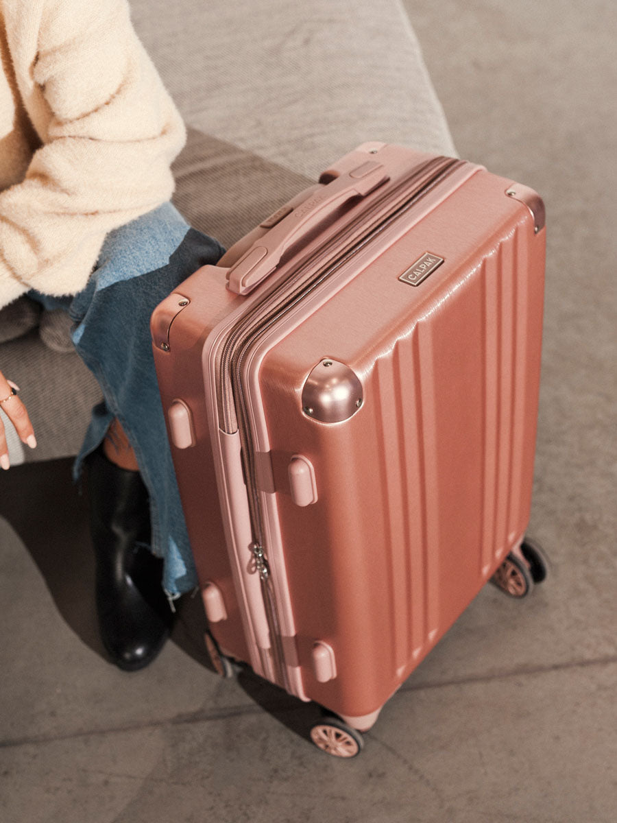 woman with rose gold CALPAK Ambeur hard shell rolling carry on; LAM1020-ROSE-GOLD;