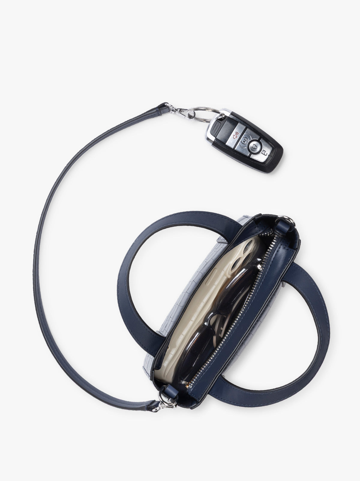 Top down view with key line and  CALPAK Haven Mini Crossbody Bag in Navy blue crocodile-embossed with top handles on a plain white background; AMC2502-NAVY-FAUX-CROC