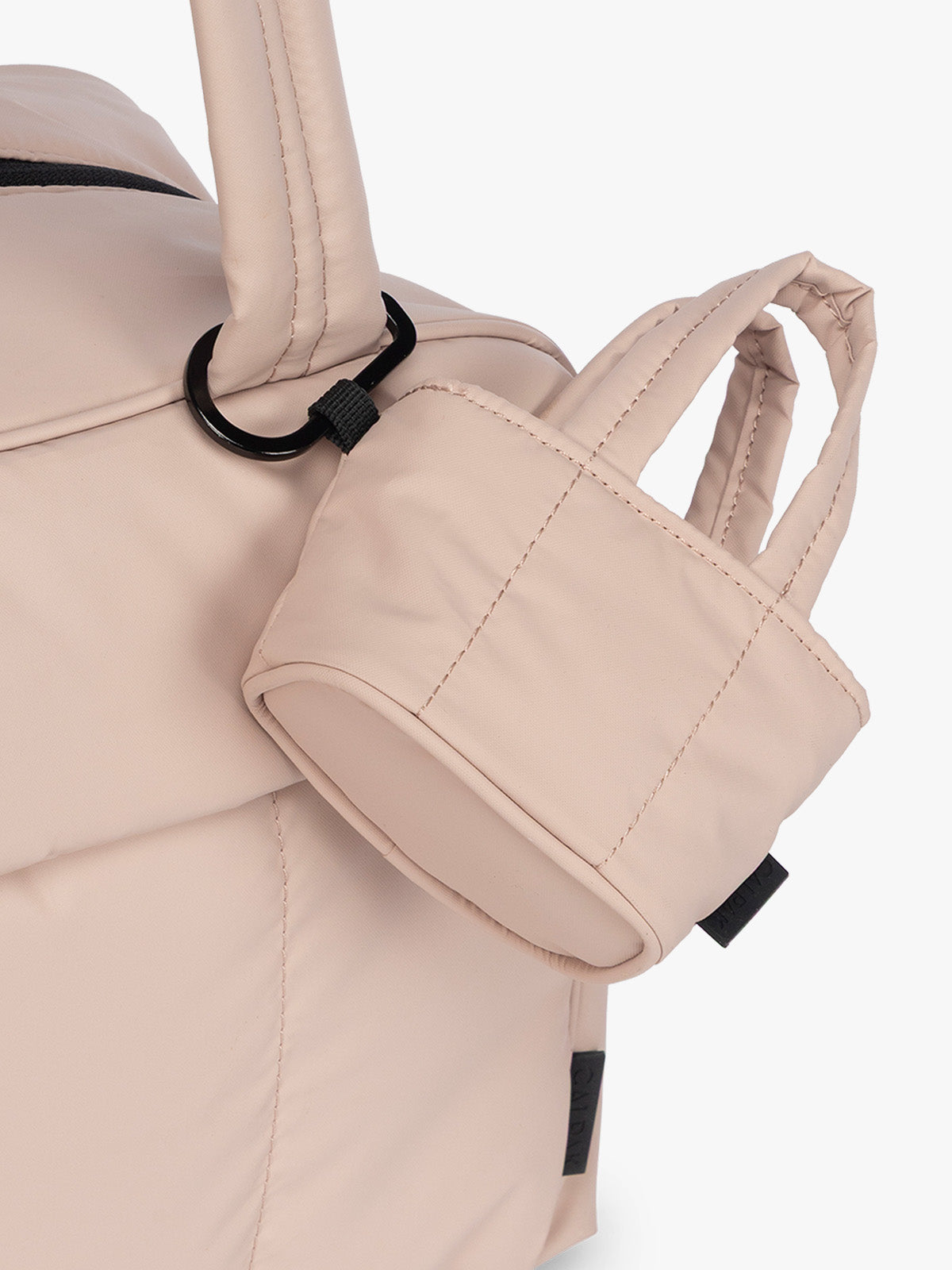 CALPAK Luka Tote Zip Bag Charm in light pink Rose Quartz  with carabiner attached to a bag; AMT2601-ROSE-QUARTZ
