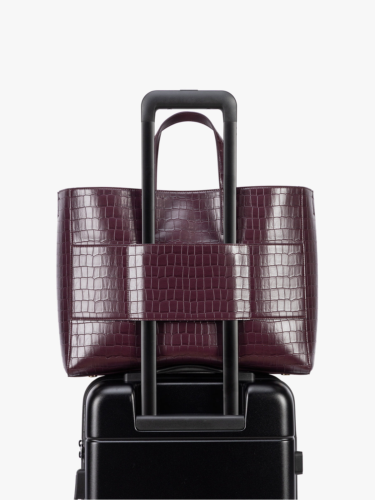 Backside luggage trolley sleeve of CALPAK Haven 16" Laptop Tote in Dark Cherry deep red crocodile-embossed tote bag with top handles and a detachable shoulder strap, shown against a plain white background; ATO2102-DARK-CHERRY-FAUX-CROC