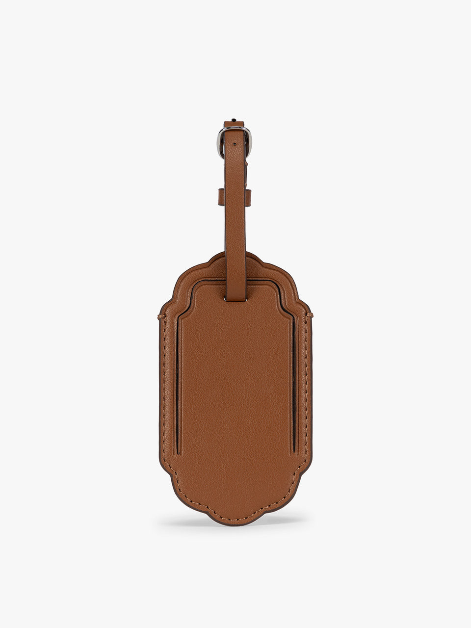 A honey brown CALPAK Vault luggage tag with a scalloped border and a matching honey brown strap, shown against a plain white background; ATV2601-HONEY-BROWN