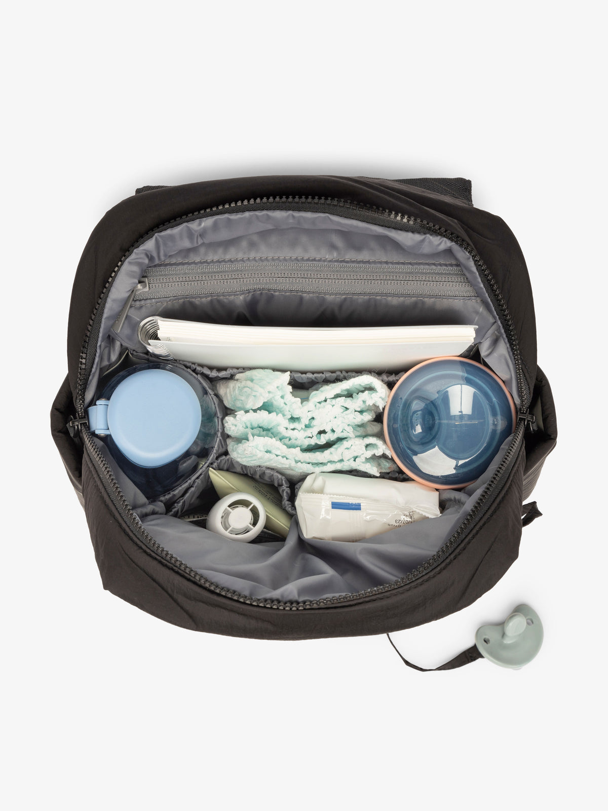 Inside view with baby items of the CALPAK Mini Diaper Backpack in Black on a white background; BPC2402-BLACK