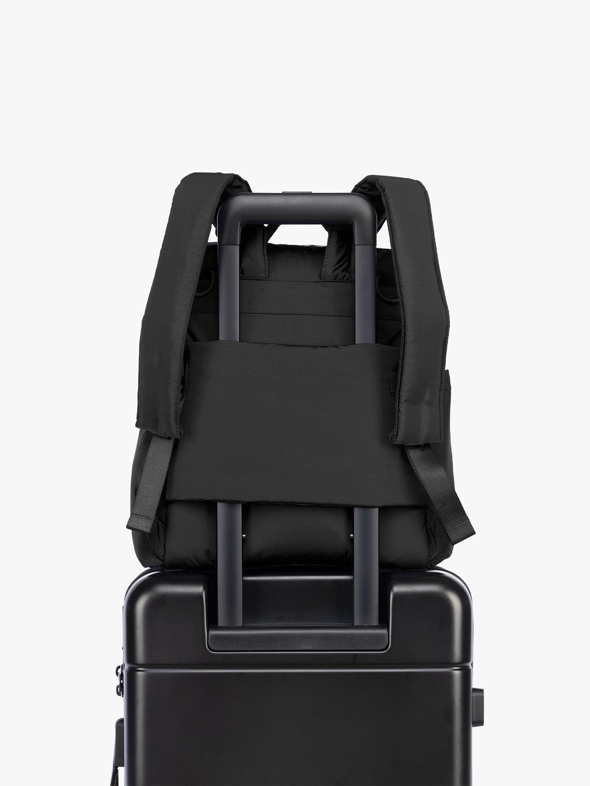 Luggage trolley sleeve of the CALPAK Mini Diaper Backpack in Black on a white background; BPC2402-BLACK