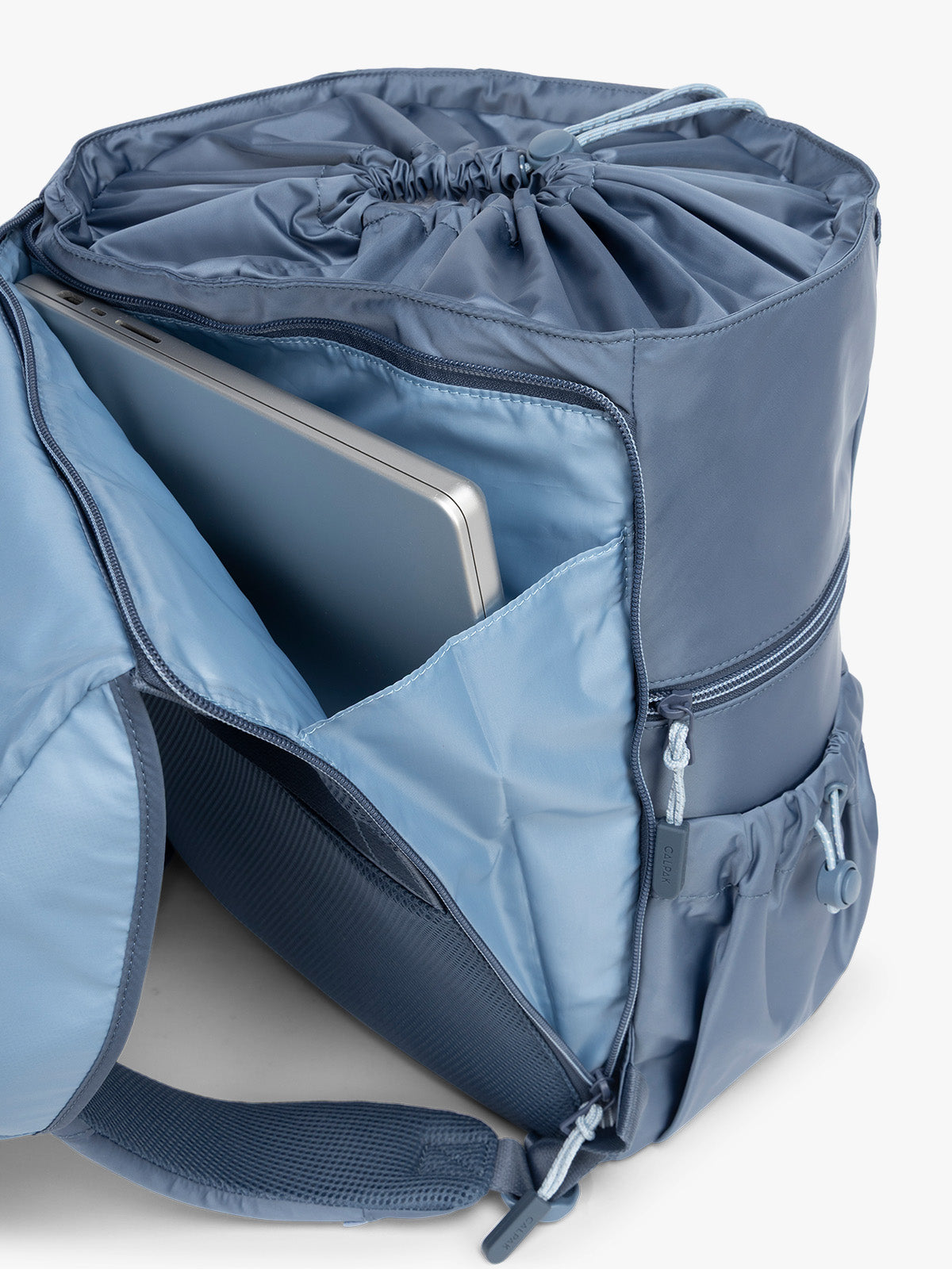 Laptop sleeve on the back of CALPAK Fit Gym Backpack in blue Indigo with white background; BPF2601-INDIGO