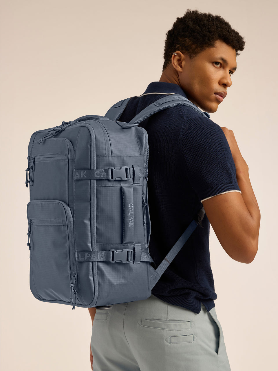 Model wearing the CALPAK Terra 26L Laptop Backpack Duffel in blue Matte Indigo; BPH2201-INDIGO