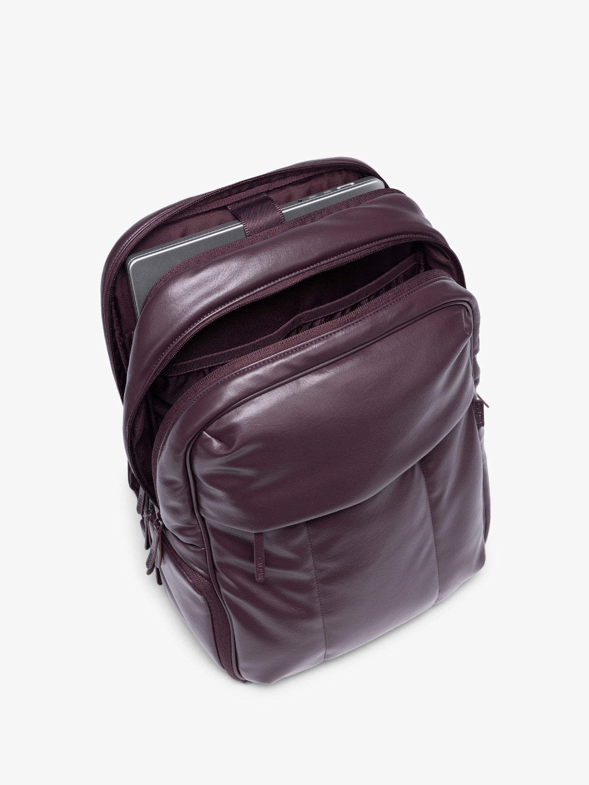 Laptop sleeve of CALPAK Dark Cherry Luka 15 inch Laptop Backpack in vegan leather with a glossy finish, featuring a top carry handle, a main zippered compartment, and a front slip pocket, shown against a plain white background; BPL2001-DARK-CHERRY-PU