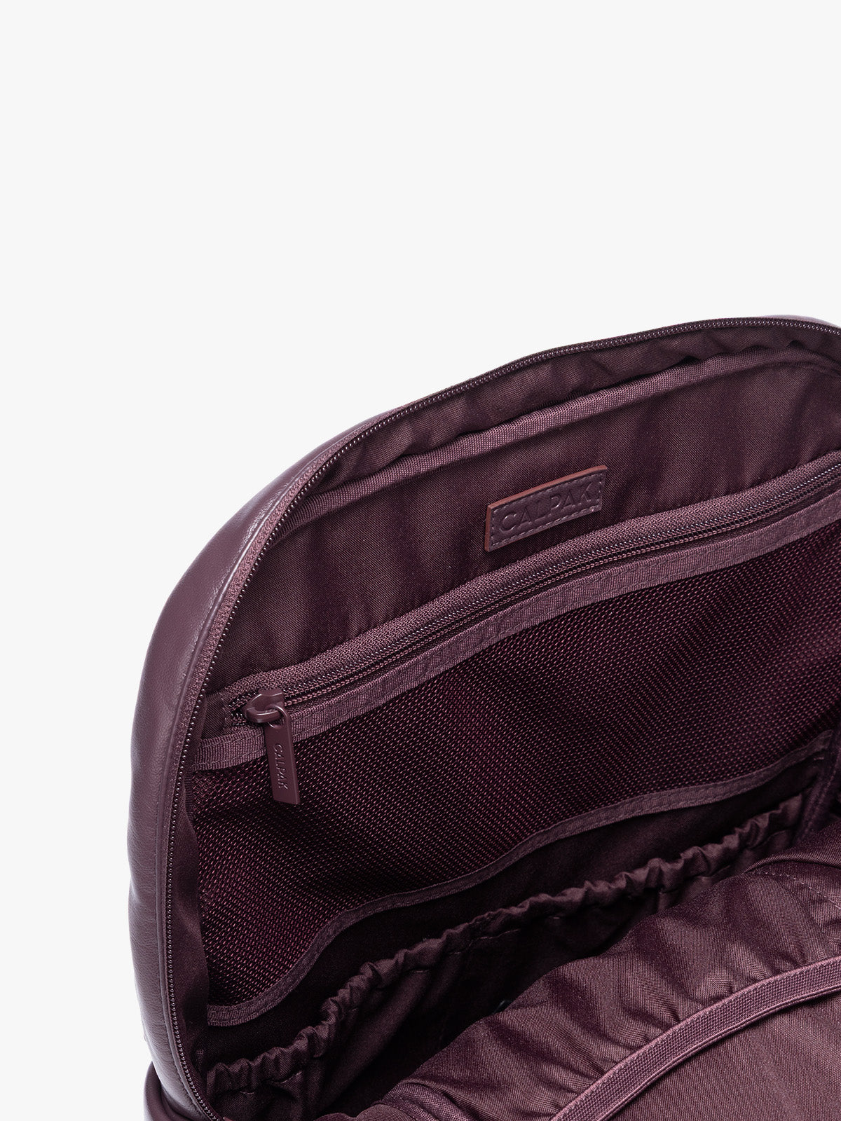 Inside zipper of CALPAK Dark Cherry Luka 15 inch Laptop Backpack in vegan leather with a glossy finish, featuring a top carry handle, a main zippered compartment, and a front slip pocket, shown against a plain white background; BPL2001-DARK-CHERRY-PU