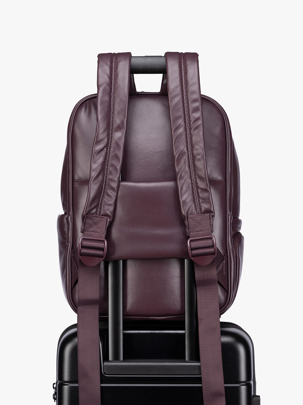 Back luggage trolley sleeve of CALPAK Dark Cherry Luka 15 inch Laptop Backpack in vegan leather with a glossy finish, featuring a top carry handle, a main zippered compartment, and a front slip pocket, shown against a plain white background; BPL2001-DARK-CHERRY-PU