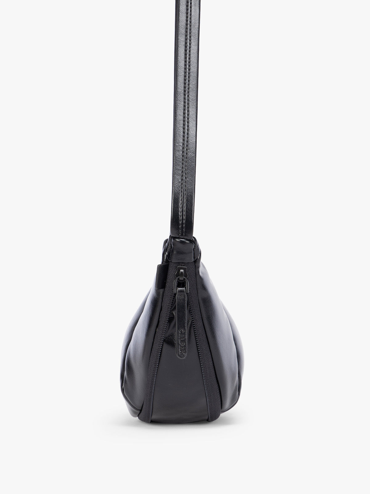 Side expandable zipper of Black vegan leather Luka Crescent shoulder bag with a long thin strap, shown against a plain light gray background; CBL2601-BLACK-PU