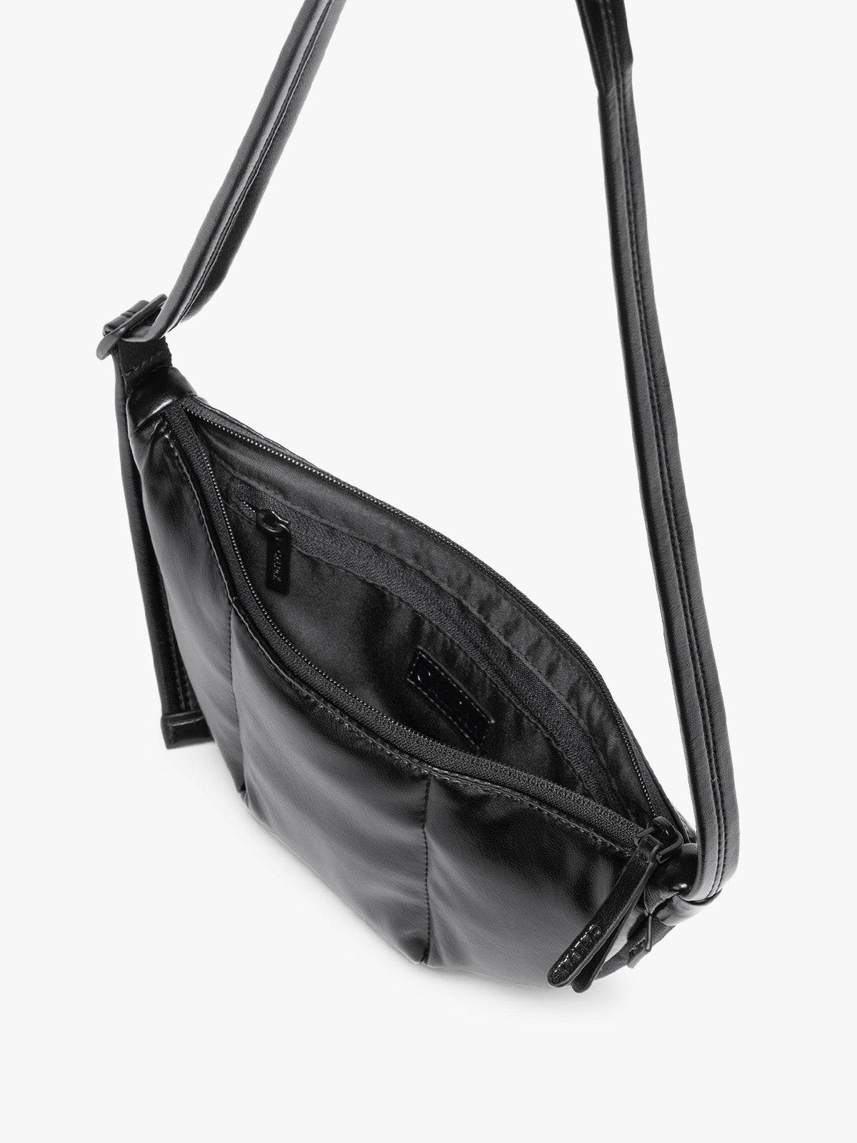 Top view with zipper opening of Black vegan leather Luka Crescent shoulder bag with a long thin strap, shown against a plain light gray background; CBL2601-BLACK-PU