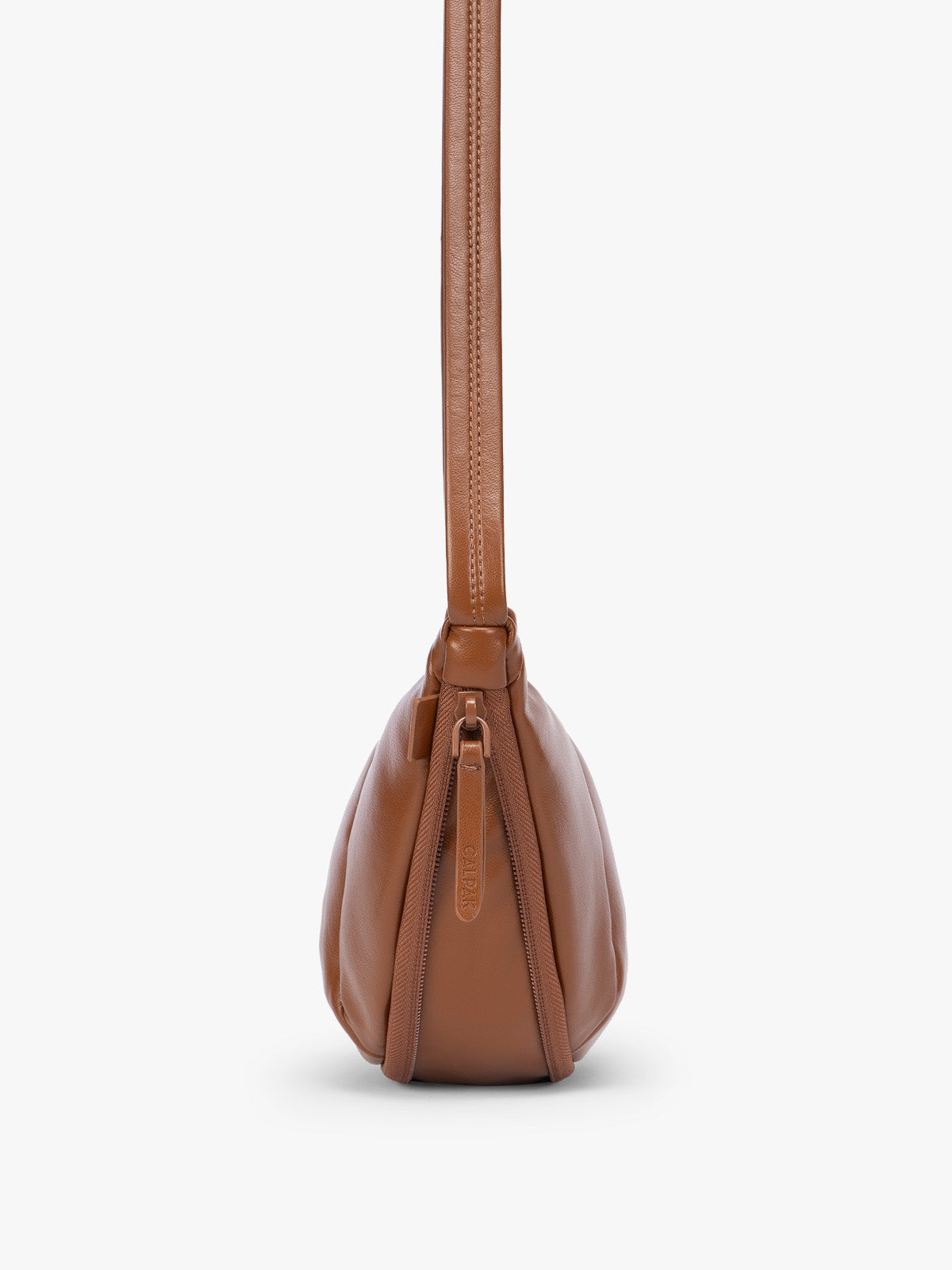 Side expandable zipper of Honey Brown vegan leather Luka Crescent shoulder bag with a long thin strap, shown against a plain light gray background; CBL2601-HONEY-BROWN-PU
