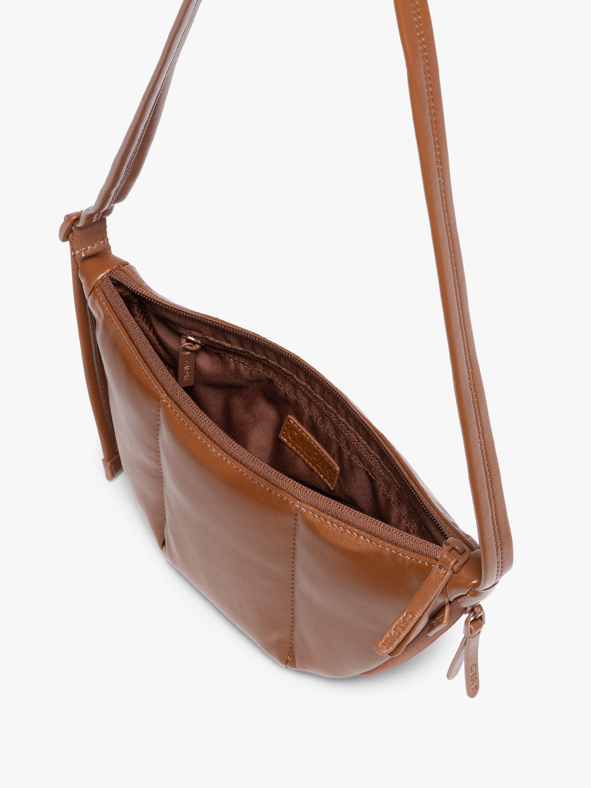Top view with zipper opened of Honey Brown vegan leather Luka Crescent shoulder bag with a long thin strap, shown against a plain light gray background; CBL2601-HONEY-BROWN-PU