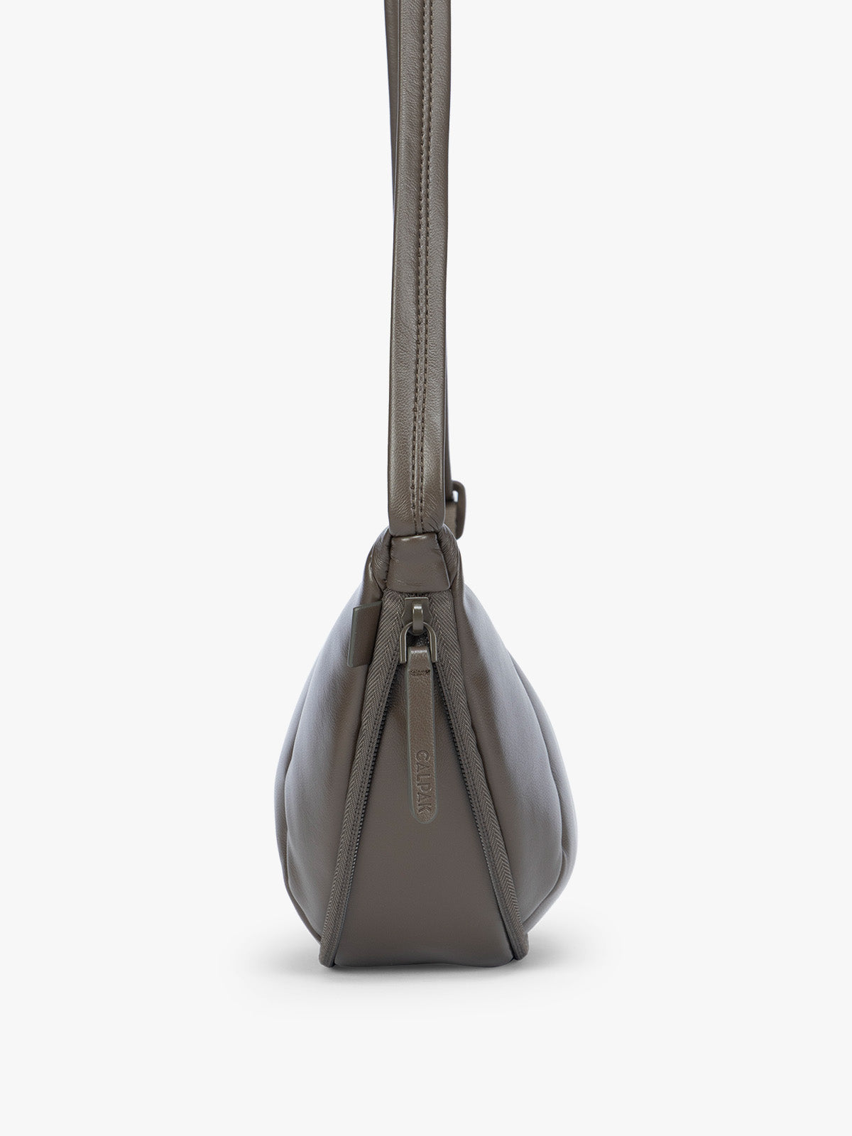 Side expandable zipper of a dark brown vegan leather Luka Crescent shoulder bag with a long thin strap, shown against a plain light gray background; CBL2601-MUSHROOM-PU