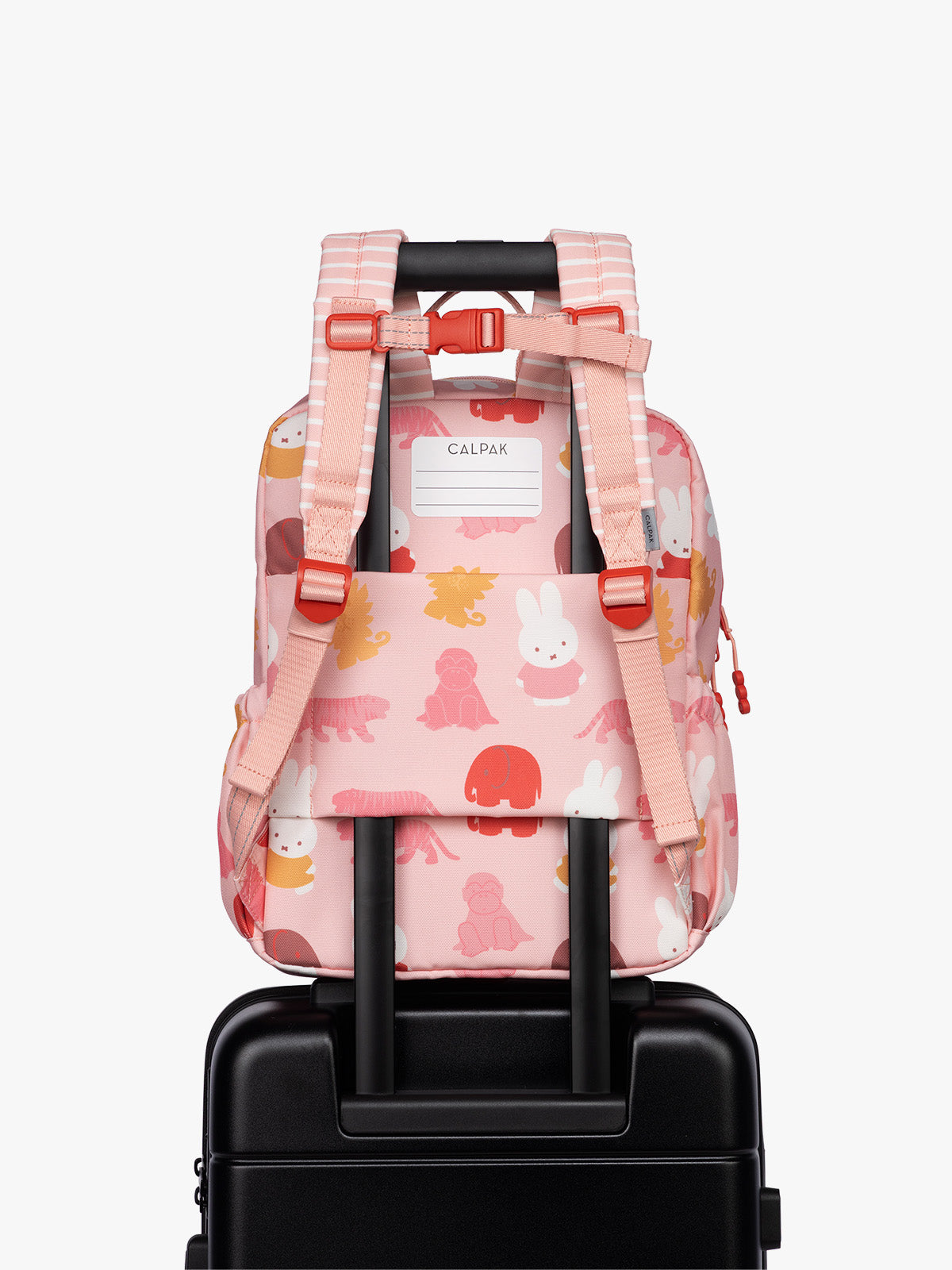 Back luggage trolley sleeve of CALPAK Kids Medium Backpack with Miffy and pink colorful animal pattern on a white background; CKBM2501-MIFFY-PINK-ZOO-TRIP