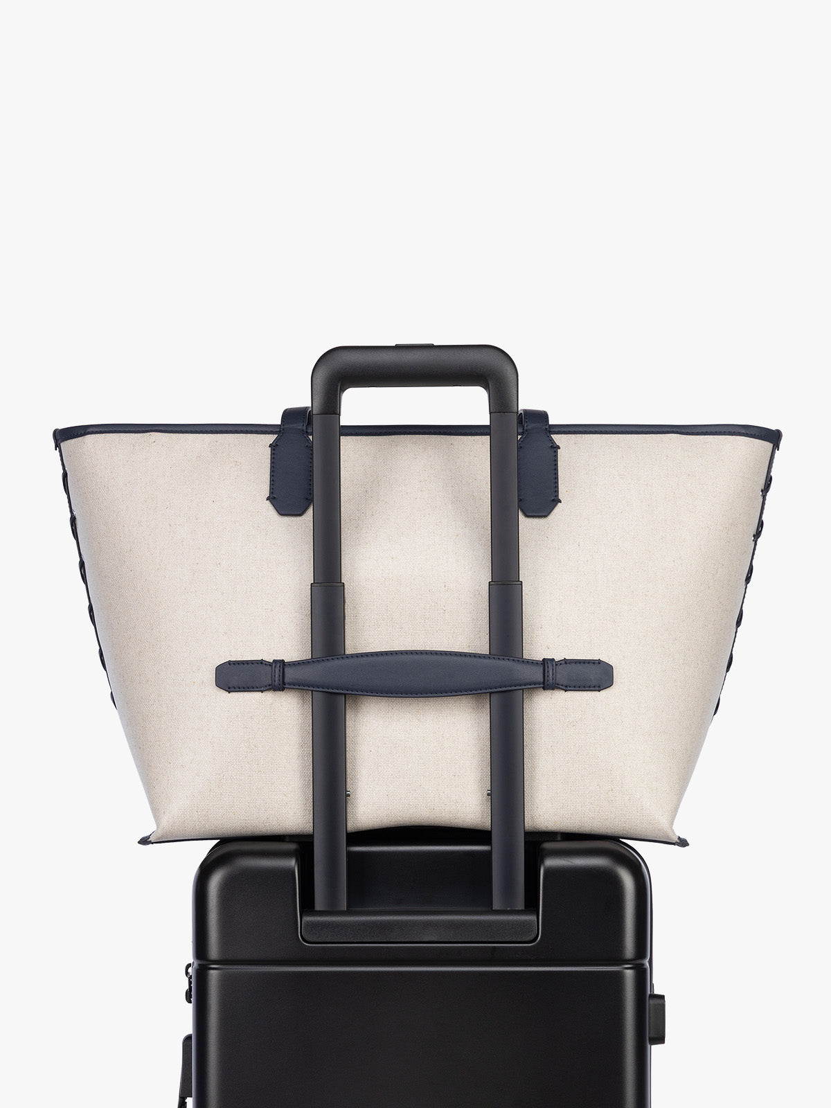 Trolley sleeve of CALPAK Colette 15" Canvas Laptop Tote in beige canvas material  with blue finishing in Natural Navy; CLCT2601-NATURAL-NAVY