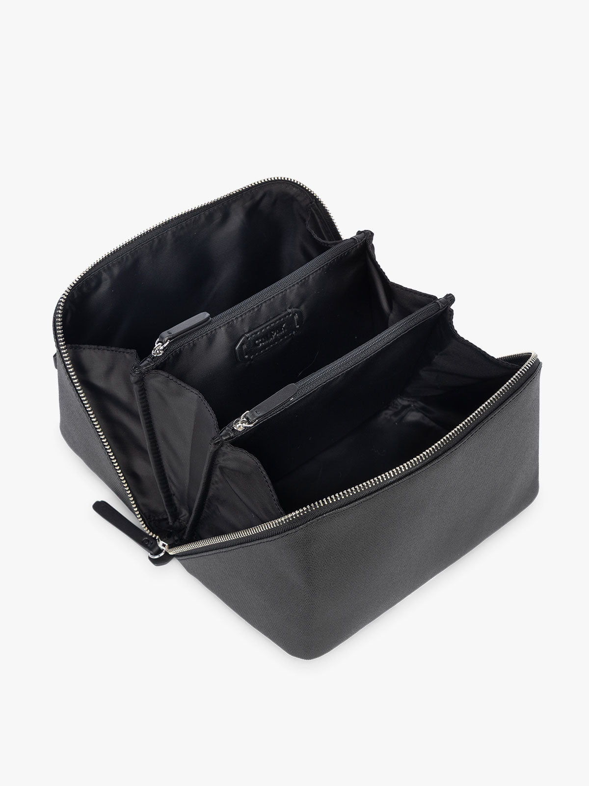 Opened CALPAK Colette Lay-Flat Canvas Toiletry Bag in black canvas material laid open flat; CLTB2601-BLACK