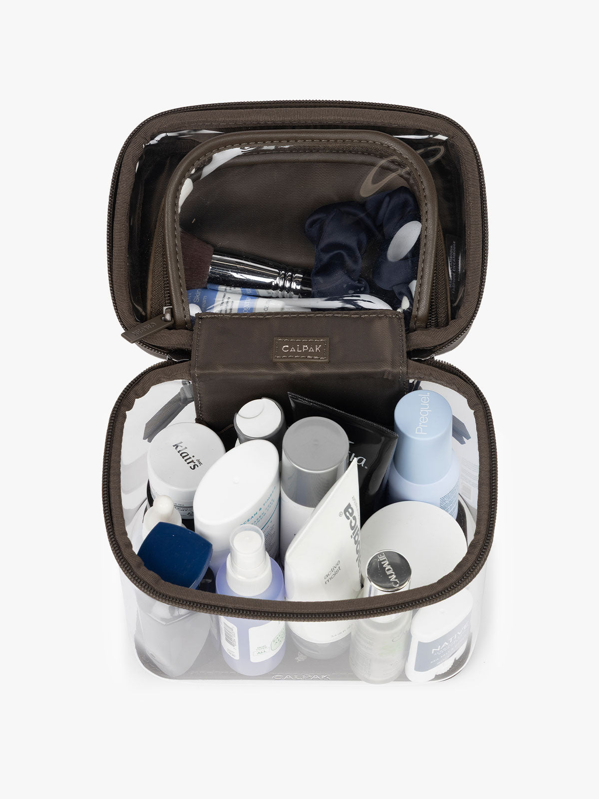 Toiletries inside the CALPAK Clear Train Case in brown Mushroom; CTC2401-MUSHROOM