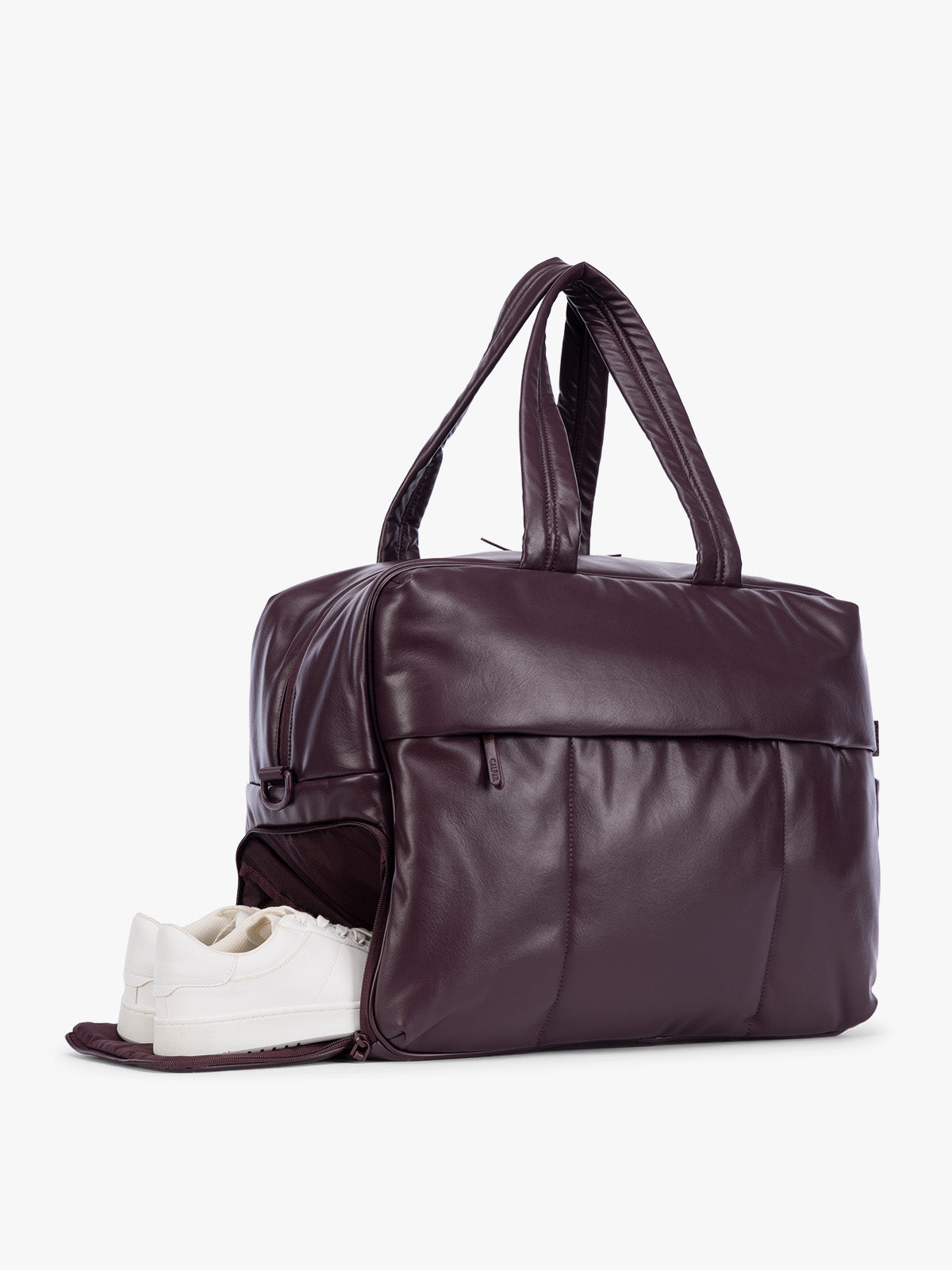 Side shoe compartment of Dark Cherry deep burgundy CALPAK Luka Large Duffel in vegan leather with dual top handles, shown against a plain white background; DLL2201-DARK-CHERRY-PU