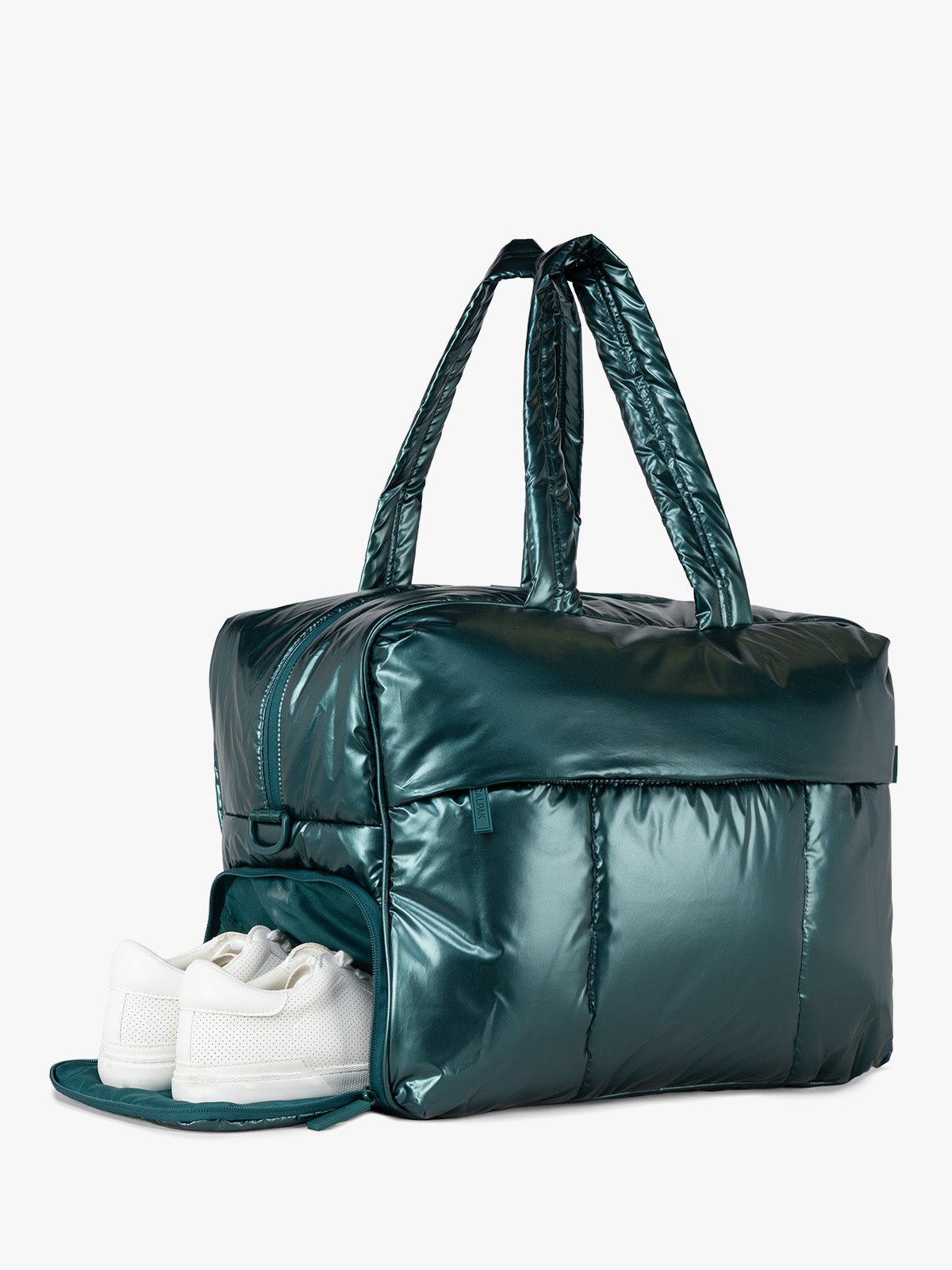 A metallic dark green puffer CALPAK Luka Large Duffel bag with dual top handles, shown with white sneakers tucked into the front zippered shoe compartment, on a clean white background; DLL2201-GLAZED-KALE