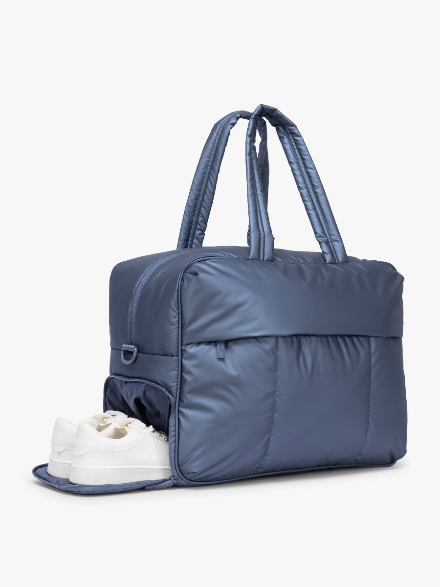 Shoe compartment of  CALPAK Luka Large Duffel in dark blue metallic material in Metallic Indigo; DLL2201-METALLIC-INDIGO