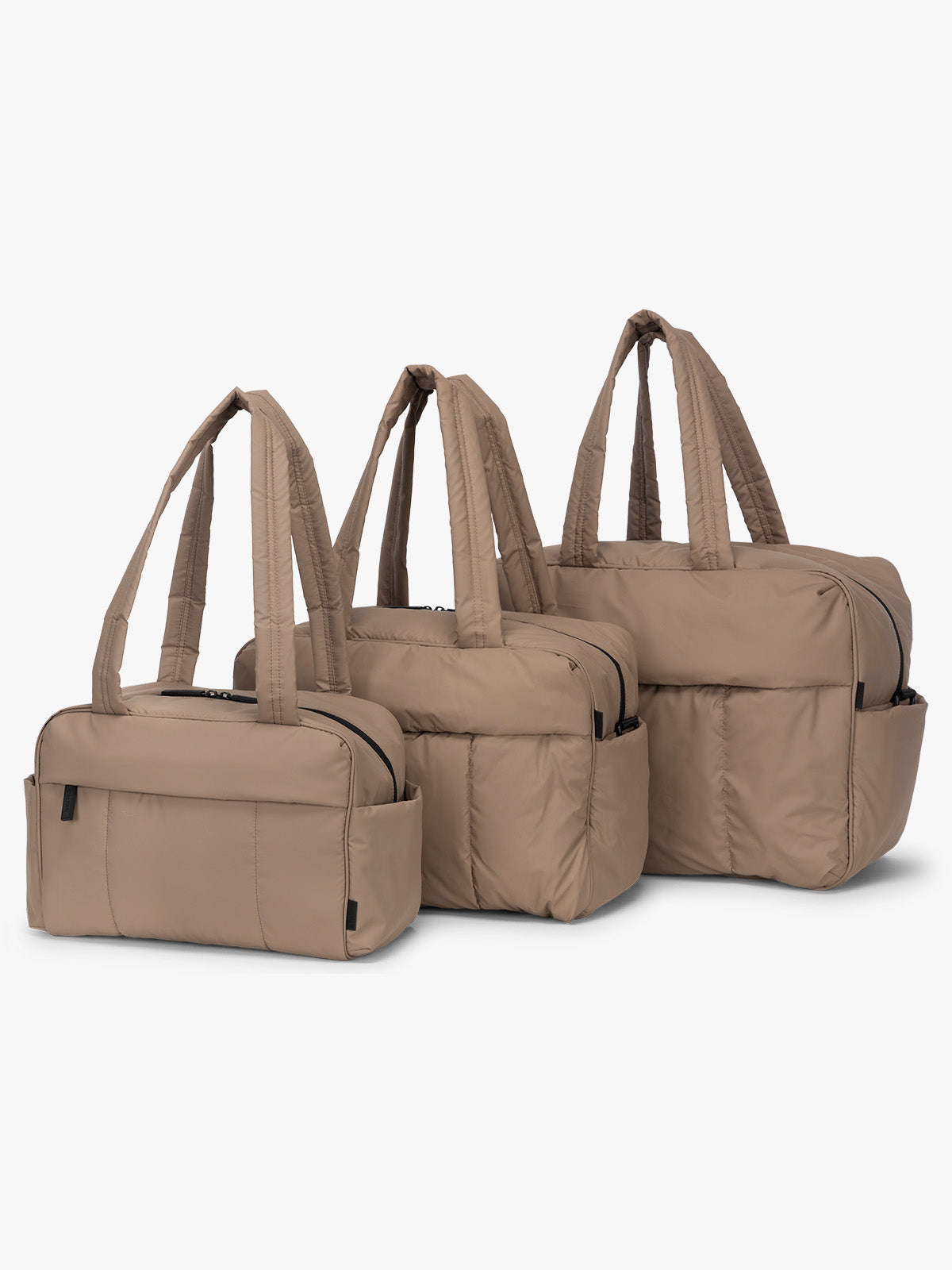 CALPAK Mini Duffel, Luka Duffel, and Luka Large Duffel in brown Chocolate front view with puffy exterior, interior and exterior pockets, and padded shoulder straps; DLM2501-CHOCOLATE