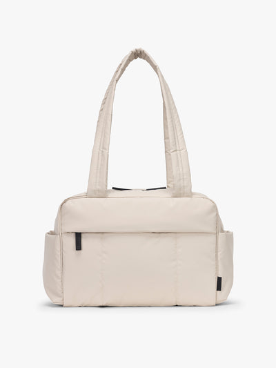 CALPAK Mini Duffel in white Oatmeal front view with puffy exterior, interior and exterior pockets, and padded shoulder straps; DLM2501-OATMEAL