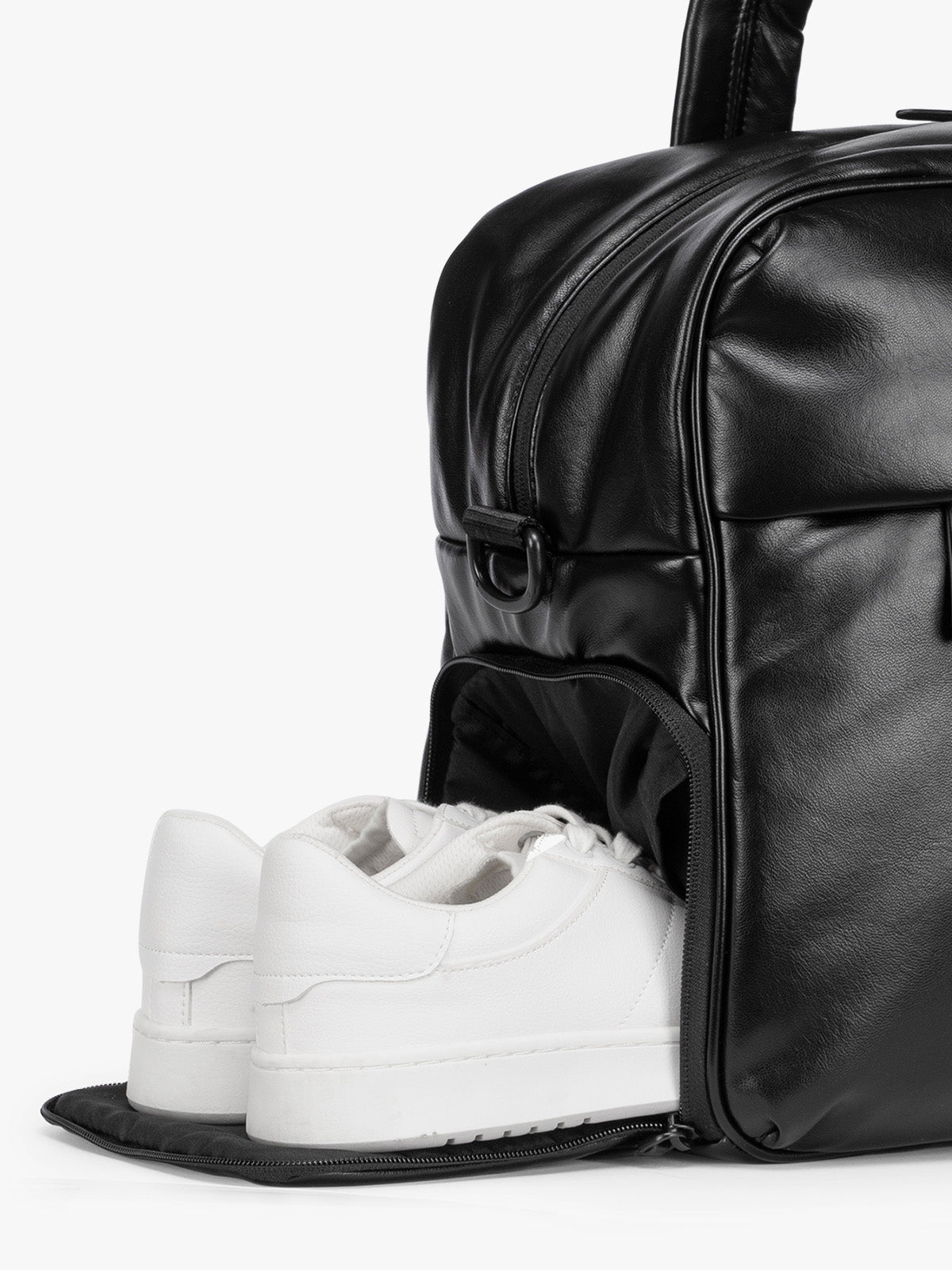 Side shoe compartment of the Black CALPAK Luka Duffel in vegan leather with dual top handles and a front zippered pocket, photographed against a clean white background; DSM1901-BLACK-PU