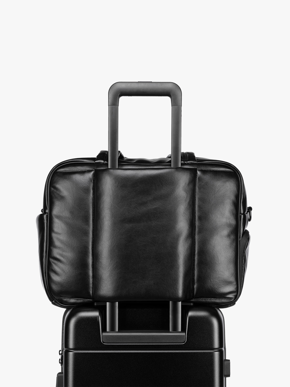 Luggage trolley sleeve of the Black CALPAK Luka Duffel in vegan leather with dual top handles and a front zippered pocket, photographed against a clean white background; DSM1901-BLACK-PU
