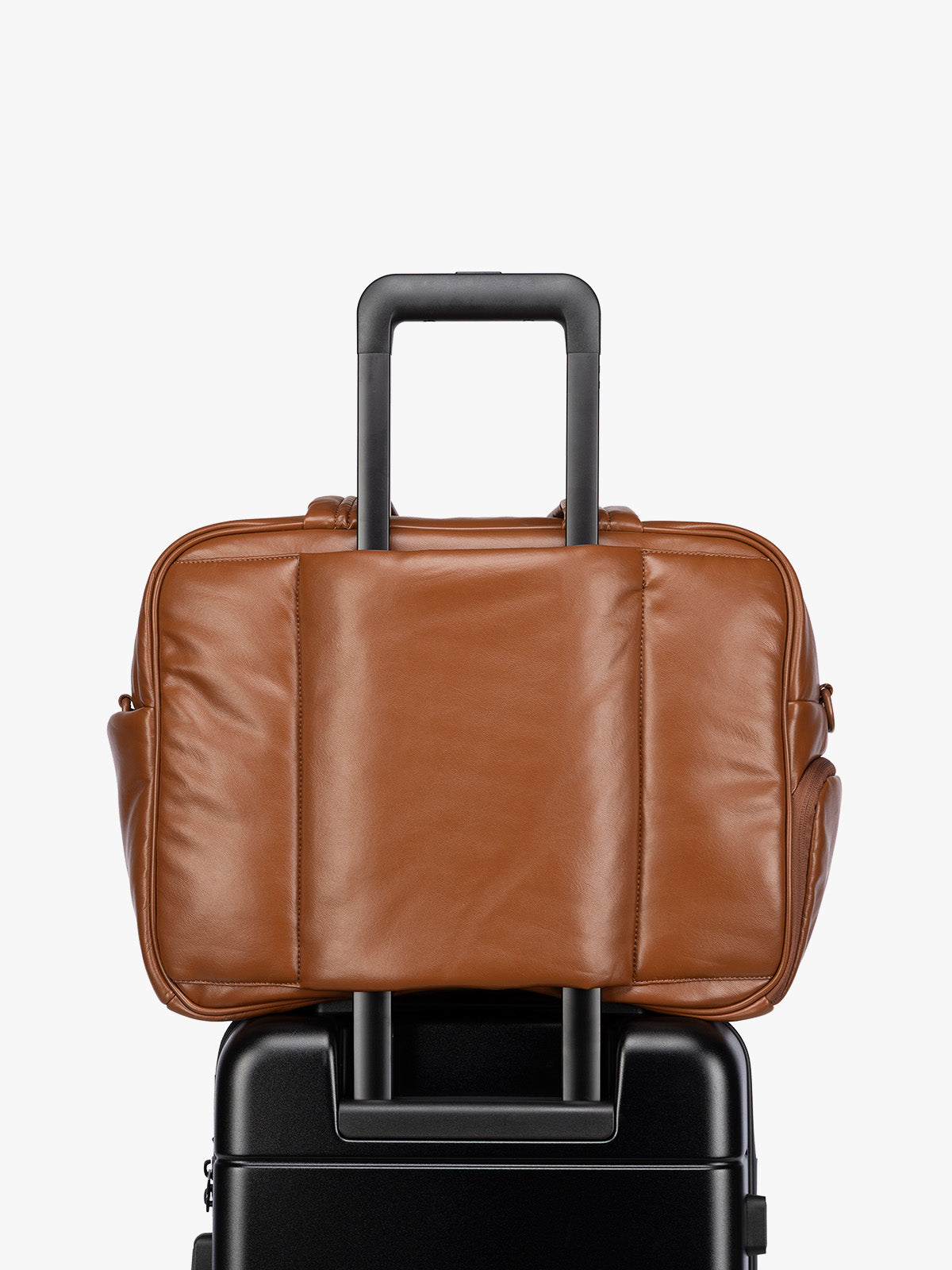 Luggage trolley sleeve of Honey Brown CALPAK Luka Duffel in vegan leather with dual top handles and a front zippered pocket, photographed against a clean white background; DSM1901-HONEY-BROWN-PU