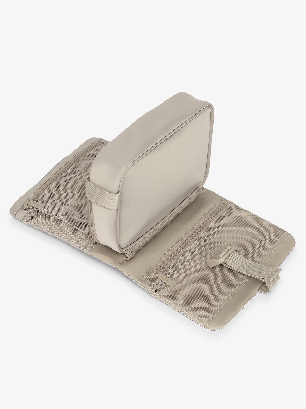 Flat lay of CALPAK Fit gym dopp kit with multiple interior mesh pockets in greige; TFH2401-GREIGE, TFH2401-GREIGE-GRIN, BTBF2401-GREIGE
