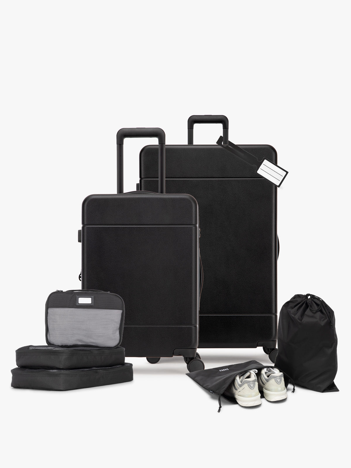 Opened CALPAK Hue Starter Bundle in Black that comes with Large and Carry On Luggage, Luggage Tag, Two Black Pouches, and Three Black Packing Cubes shown on a white background; LHU8000-BLACK