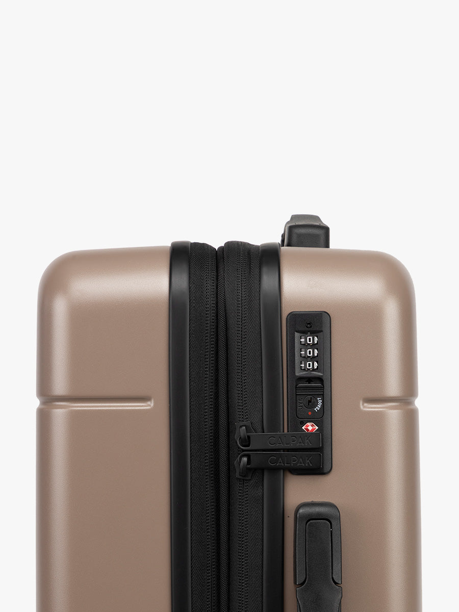 TSA-approved lock on the CALPAK Hue Starter Bundle in brown Chocolate that comes with Large and Carry On Luggage with op handle on a white background; LHU8000-CHOCOLATE