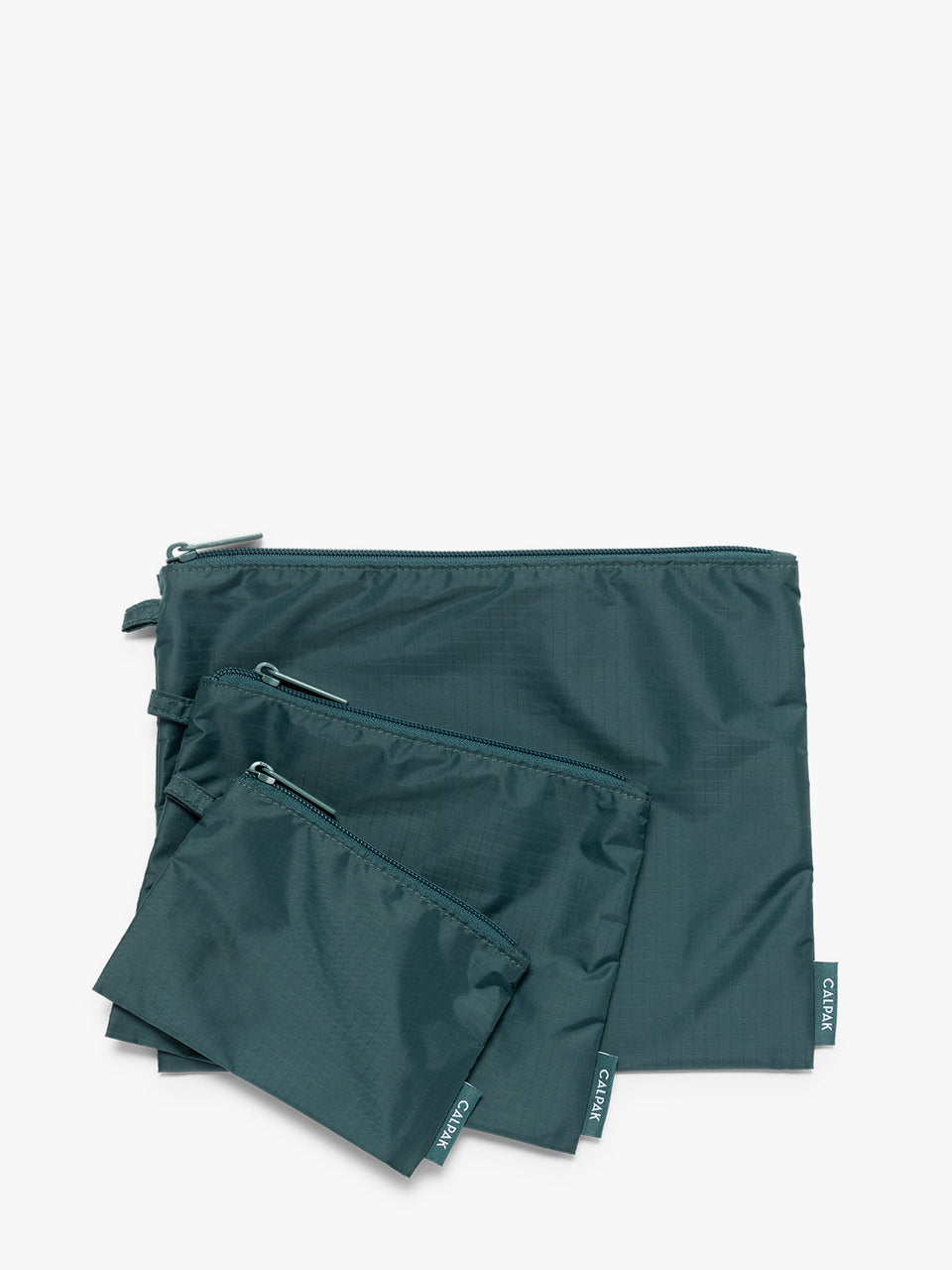 Three dark green teal Kale CALPAK Compakt Zippered pouches of different sizes, arranged in a fan-like layout on a clean white background; KZB2001-KALE