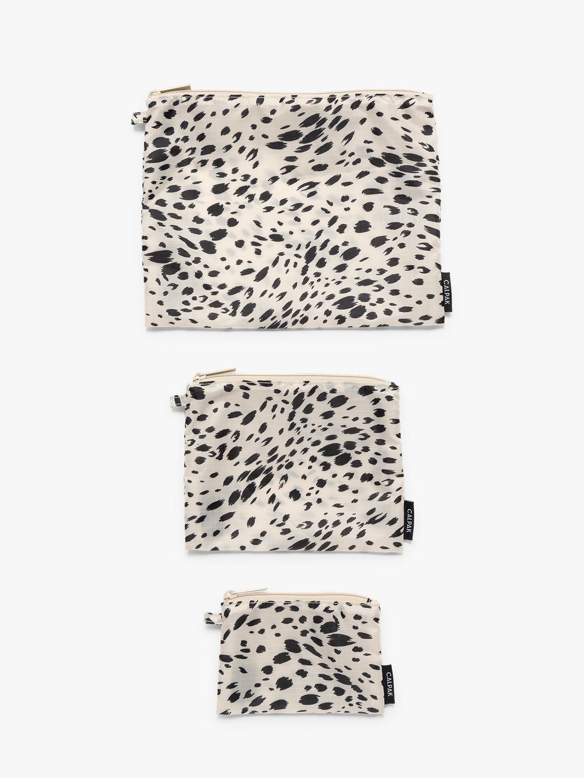 Flat lay of white and black animal print Snow Leopard CALPAK Compakt Zippered pouches of different sizes, on a clean white background; KZB2001-SNOW-LEOPARD
