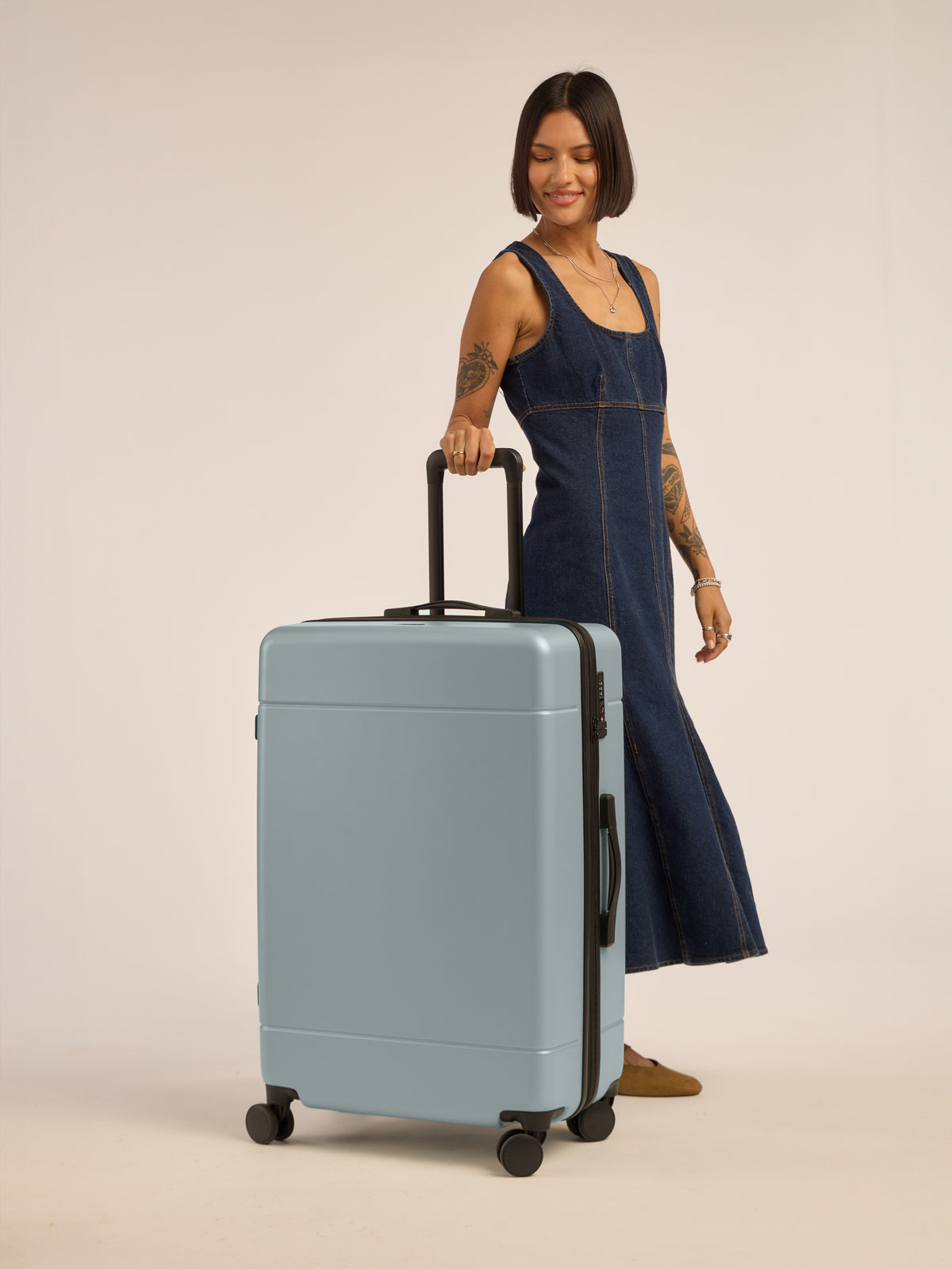 Model with CALPAK Hue Large Luggage in blue Bluebell; LHU1028-BLUEBELL