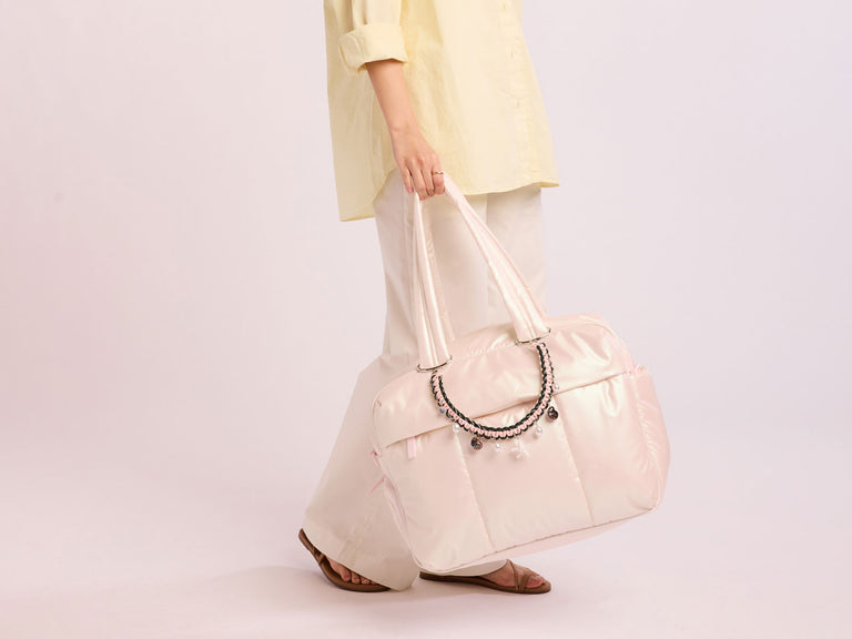 Person holding CALPAK Luka Duffel in Pearlescent in hand