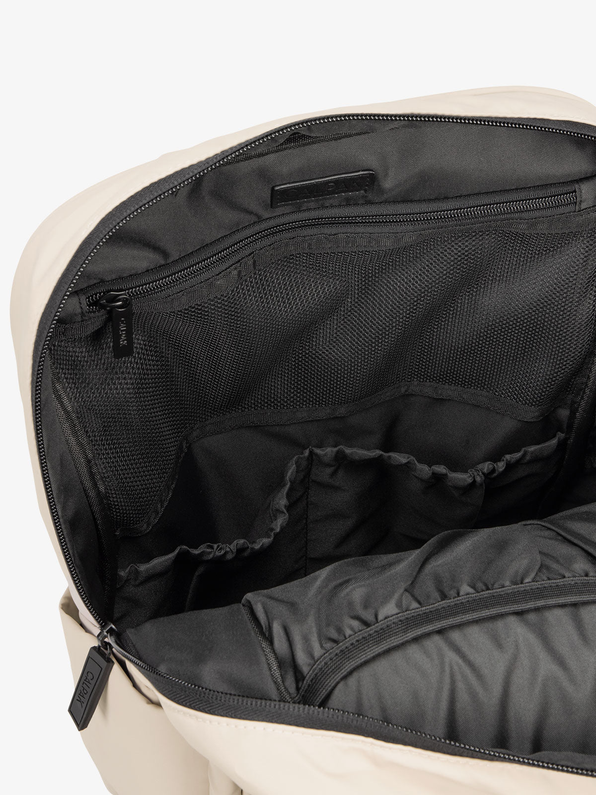 Close up of main compartment of CALPAK laptop backpack with multiple interior pockets in oatmeal; BPX2301-OATMEAL