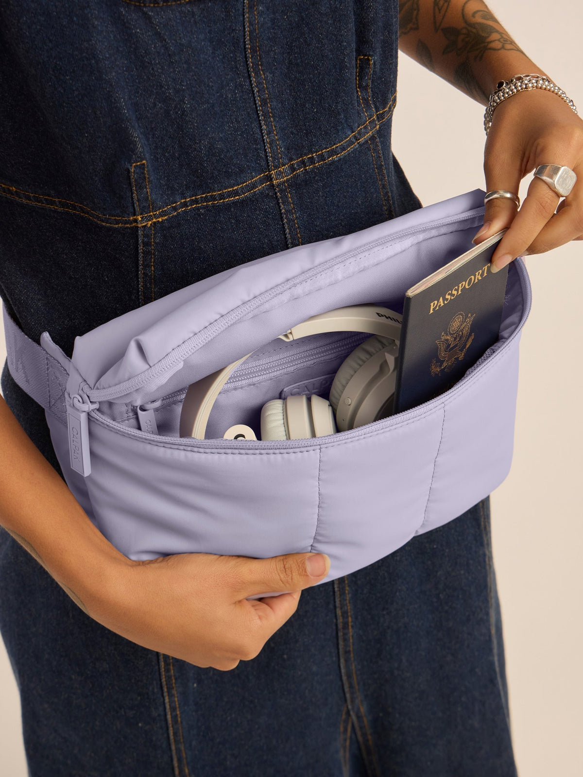 Model opening CALPAK Luka Belt Bag fanny pack bag in Orchid lavender purple; BB1901-ORCHID